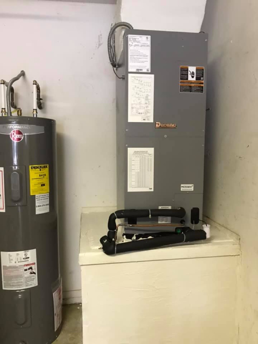 A Ducane air handler installed indoors with insulated copper lines and a condensate drain